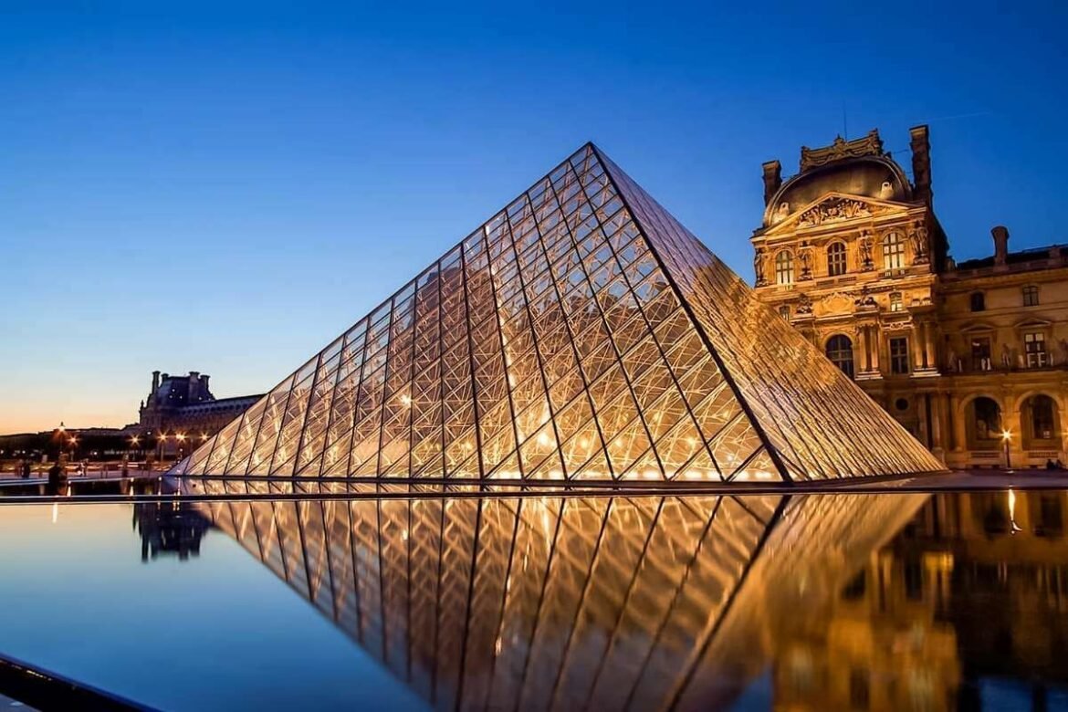 Fachada do Museu do Louvre com a pirâmide de vidro em Paris, mostrando a entrada principal onde os visitantes utilizam seu museu do Louvre ingresso