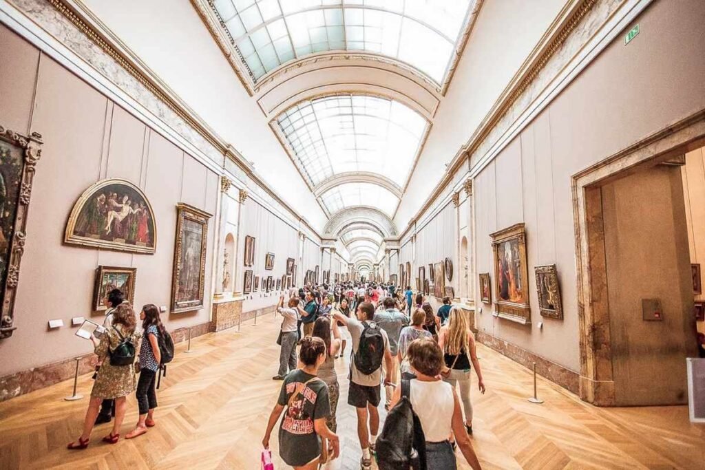 Vista panorâmica do interior do Museu do Louvre com visitantes admirando as obras com seu museu do Louvre ingresso Vista panorâmica do interior do Museu do Louvre com visitantes admirando as obras com seu museu do Louvre ingresso