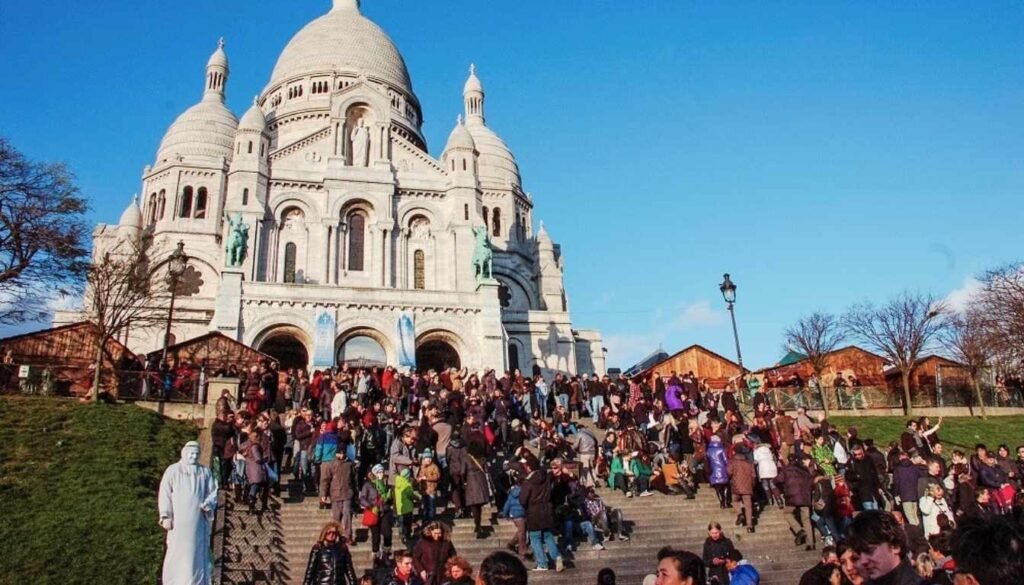 A bustling city street in Paris, with tourists cautiously navigating their surroundings. In the foreground, a well-dressed woman holds her purse close to her body, her expression wary. Behind her, a group of tourists pause to consult a map, their body language suggesting a mix of excitement and apprehension. The middle ground features a variety of pedestrians, some hurrying by, others engaged in casual conversation. The background is a blend of historic architecture, street vendors, and the occasional passing car or bus. The scene is illuminated by warm, diffused lighting, creating a sense of both familiarity and slight unease. The overall atmosphere conveys the need for vigilance and awareness when exploring the city as a tourist.