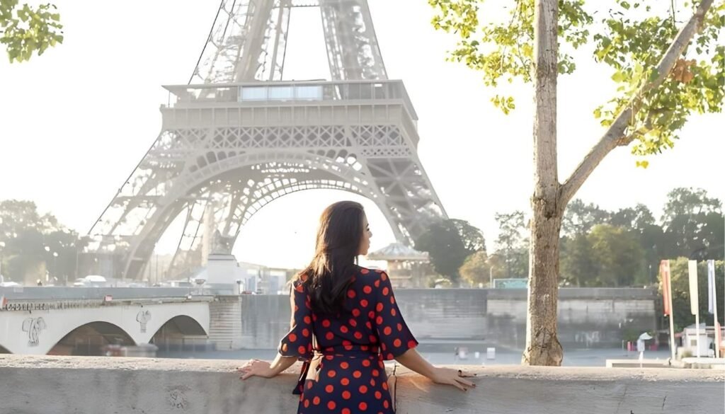 An elegant Parisian street scene, with a young traveler standing in the foreground, lost in thought as she navigates the bustling city without the aid of language. The middle ground features quaint cafes and boutiques, their facades adorned with ornate architectural details. In the background, the iconic Eiffel Tower rises majestically, its wrought-iron silhouette casting a warm, golden glow under the soft, diffused lighting of an overcast day. The overall mood is one of exploration, discovery, and a sense of personal growth, capturing the essence of the "experiência" of visiting Paris without the comfort of a shared language. paris sem falar ingles - contemplando a torre eiffel